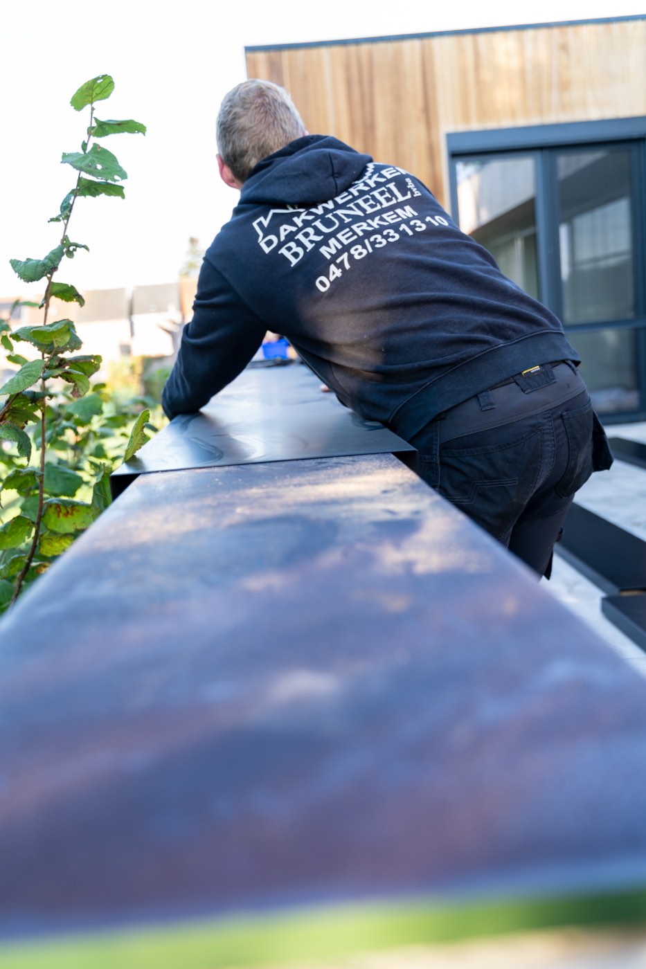 Dakwerker van Dakwerken Bruneel plaatst een zinken dakrand op een woning
